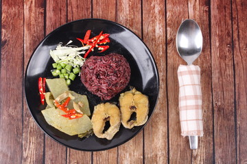 Brown jasmine rice topped green chicken curry and fish.
