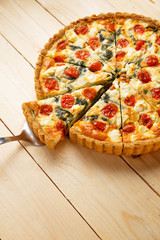 Vegetarian homemade pie, Quiche with tomatoes, spinach and feta cheese.