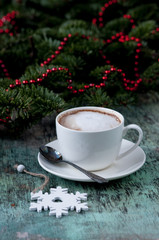 A cup of coffee on a wooden background. Coffee cappuccino with Christmas decorations and fir branches on the old wooden background. Cocoa Cappuccino Coffee Cup of coffee Wooden background