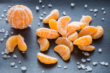 Pieces of mandarin. Composition of tangerines on the dark background.