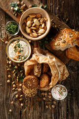 Falafel, delicious dips and roasted almonds, excellent vegan appetizers on rustic wooden table, top view