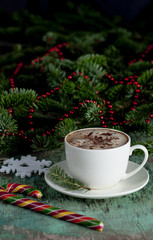 A cup of coffee on a wooden background. Coffee cappuccino with Christmas decorations and fir branches on the old wooden background. Cocoa Cappuccino Coffee Cup of coffee Wooden background