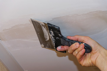 The hand of the employee to use stucco on the ceiling joints
