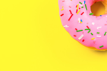 Pink round donut on yellow background. Flat lay, top view.