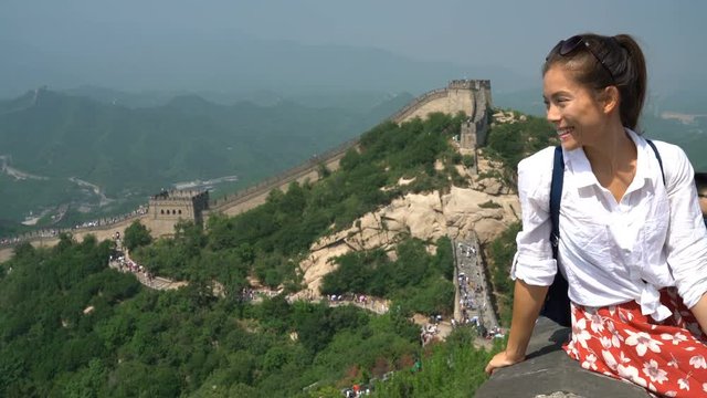 Great Wall of China. Woman tourist on travel waving hand saying hello to camera by famous Chinese tourist destination and attraction in Badaling north of Beijing. Woman traveler on vacation.