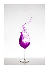 violett farbener Wassersplash im Glas mit Spritzern - Liquid Art, Weinsplash im Glas