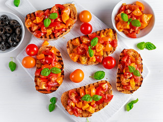 Tasty Traditional Tomato bruschetta with fresh basil on white board