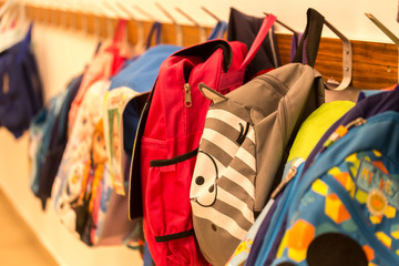 Fototapeta Children's backpacks weigh on hangers in kindergarten obraz
