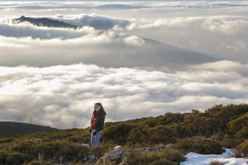 Obraz premium Momentos de libertad. Mujer mirando a cámara en la montaña con el mar de nubes a sus pies