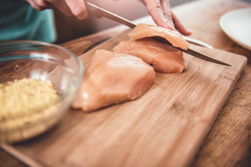 Woman cutting chicken meet