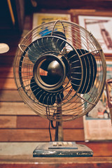 Antique fan on grunge wooden table background. (vintage style)