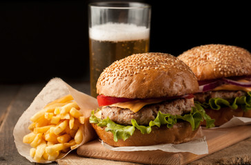 Close-up photo of home made hamburger with beer made of beef, onion, tomato, lettuce, cheese and...