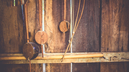 Traditional Thai musical instruments ( the Lanna of northern Thailand) on a grunge wooden wall background. (vintage style)