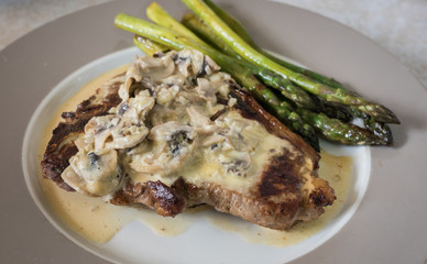 Grilling steak with rosemary, mushroom sauce and asparagus. Fresh, delicious, spicy, juicy meat, healthy.