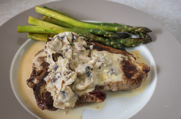 Grilling steak with rosemary, mushroom sauce and asparagus. Fresh, delicious, spicy, juicy meat, healthy.