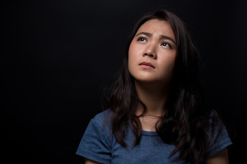 Naklejka premium Sad woman on isolated black background