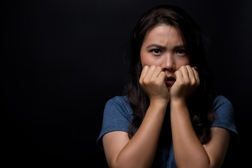 Scared woman on isolated black background