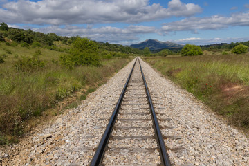 Fototapeta na wymiar Via de Tren en Recta, en Paisaje Montañoso