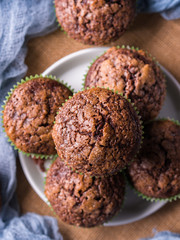 Chocolate banana muffins with sugar topping on dark blue background. Home made single portion snack. Winter baked dessert