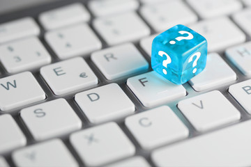Blau Türkis farbener / blauer türkiser Würfel mit Fragezeichen auf Tastatur 