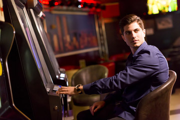 Young man with slot machine in the casino