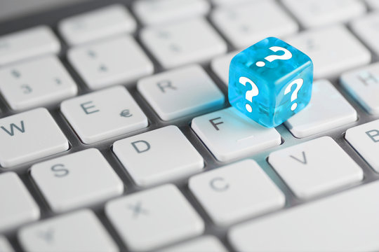 Blau T&uuml;rkis farbener / blauer t&uuml;rkiser W&uuml;rfel mit Fragezeichen auf Tastatur 
