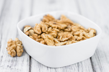 Portion of Cracked Walnuts on wooden background (selective focus