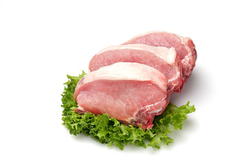 raw pork steaks, lettuce on a cutting board