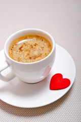a white  cup with espresso and many hearts like a cocept love for coffee