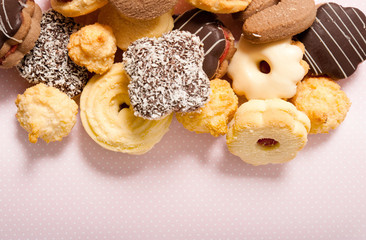 various kinds of cookies buscuits over pastel pink background with copy space