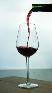falling red wine in glass