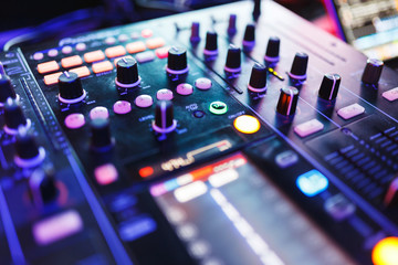 DJ mixer in bright colors disco in a nightclub. 