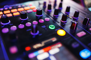 DJ mixer in bright colors disco in a nightclub. 