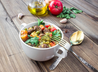 served beef meat stewed with vegetables in ceramic pot with ingredients on wooden background