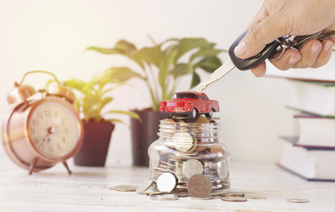 hand hold key with car and money, concept in buying,loan, selling and insurance in  Vehicles