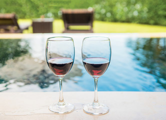 Two glasses of red wine beside the pool,Romantic