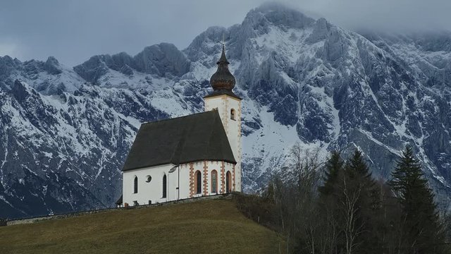 Church St. Nikolaus at a foothills. In the background the Hochkonig Mountains in Dienten,  Salzburger Land, Austria, Alps, Jan 2017 .