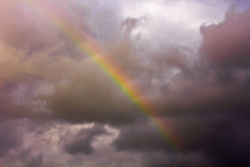 Fototapeta na wymiar Scenic storm clouds and rainbow in the dark sky.Soft focus