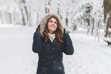 Fototapeta na wymiar Winter portrait of a beautiful woman in the snowfall