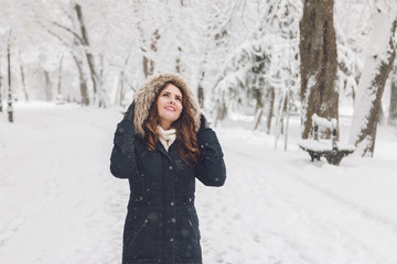 Fototapeta na wymiar Winter portrait of a beautiful woman in the snowfall