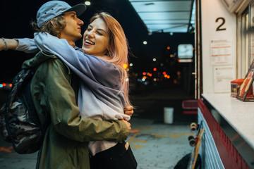 Young hipster couple hug at the street late night