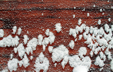 Schnee auf einer Holzplatte
