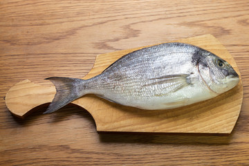 dorado fish on a wooden board top vew