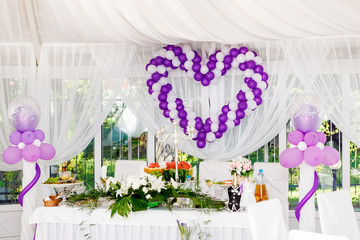 beautiful wedding decorations. Heart of white and purple balloons on a celebratory table