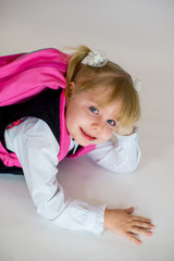 portrait of young lying schoolgirl with schoolbag
