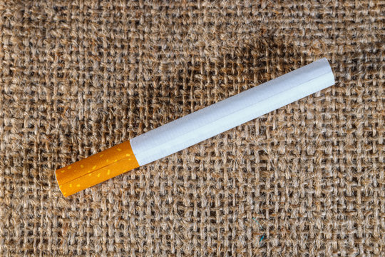 cigarette left on the brown crumled background, close up with copy space