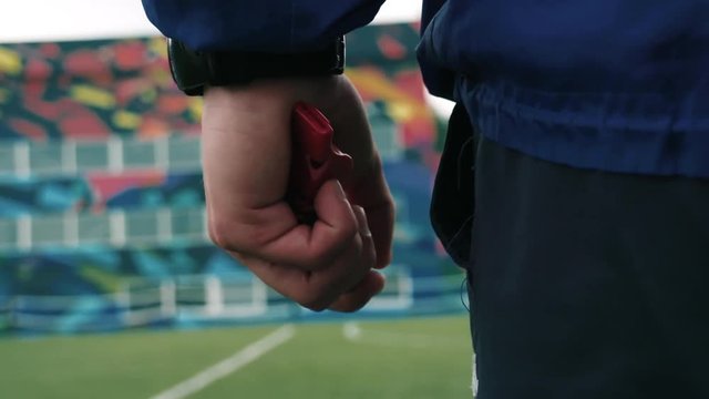 the coach holds whistle in his hand