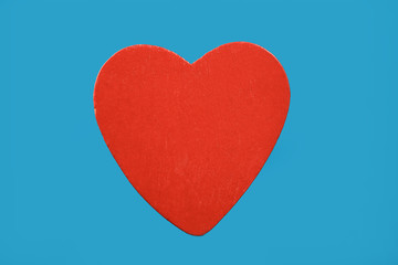 Red wooden heart isolated on blue background