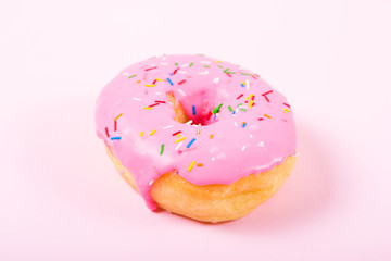 Pink round donut on pastele background. Flat lay, top view.