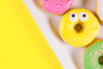 Colorful round donuts in the box. Flat lay, top view.